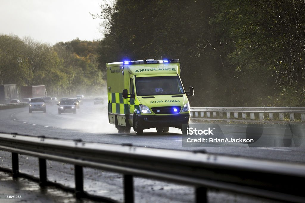 Ambulance British ambulance responding to an emergency in hazardous bad weather driving conditions on a UK motorway Ambulance Stock Photo