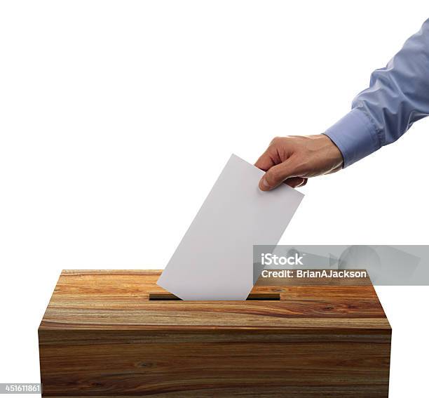 Male Placing His Voting Envelope Into A Wooden Ballot Box Stock Photo - Download Image Now