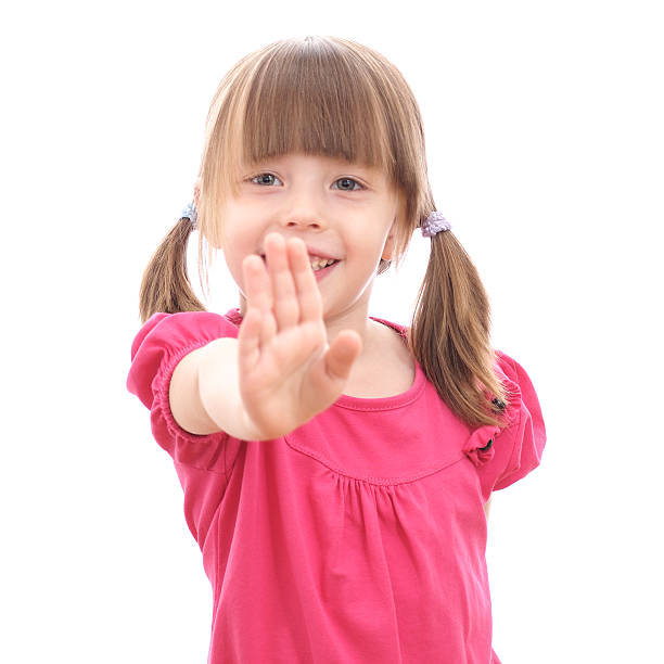 istock Smiling little girl showing her hand up 451614891