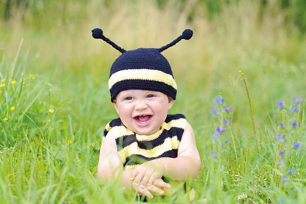 happy smiling baby in bee costume on the meadow baby age of 10 months in bee costume on the meadow bee costume stock pictures, royalty-free photos & images