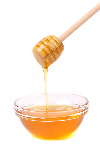 istock Bee honey with wooden dipper 451616441