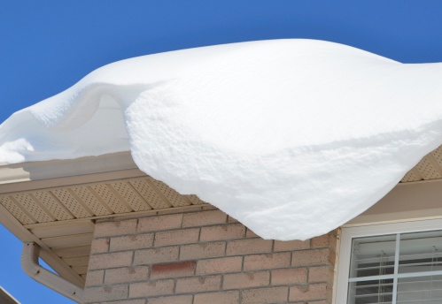 closeup of snow pile up on a roof ready to fall down