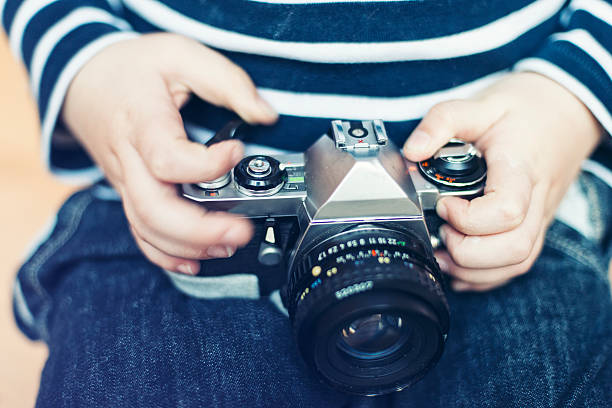 istock Old retro camera in the hands of a child 451623627