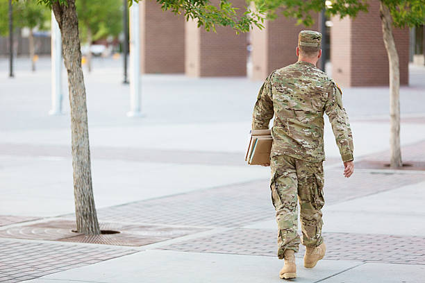 American Soldier with books US soldier in uniform walking towards a building with books under his arm us military photos stock pictures, royalty-free photos & images