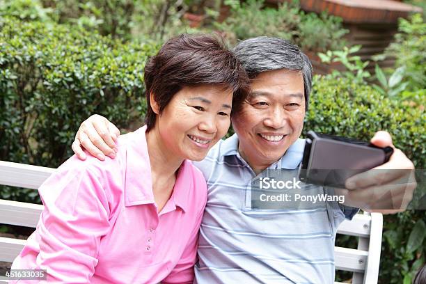 Happy Elderly Seniors Couple Smile Using Smart Phone Stock Photo - Download Image Now