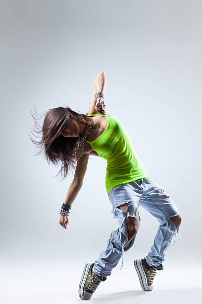 istock Female dancer with green tank top and torn jeans 451638703