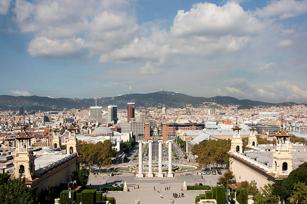 a view of the top section of the Columbus Monument in Barcelona, Spain, at the end of the popular La Rambla street, against the sky with some blank space on the left