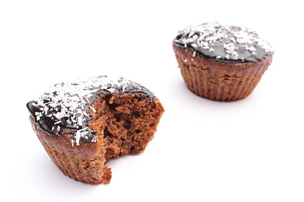 Closeup of fresh baked muffin with cacao, chocolate and desiccated coconut. Isolated on white background