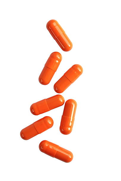 pílula cápsulas laranja - vitamin pill vitamin e isolated text imagens e fotografias de stock