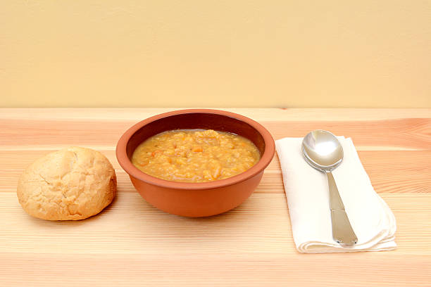 Vegetable soup in a bowl with crusty bread roll