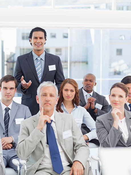 istock Businessman smiling and gesturing as he stands behind his collea 451801177