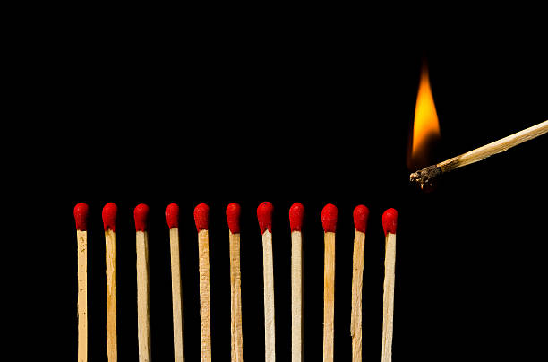 istock Burning match with row of matches isolated on black background 451803515