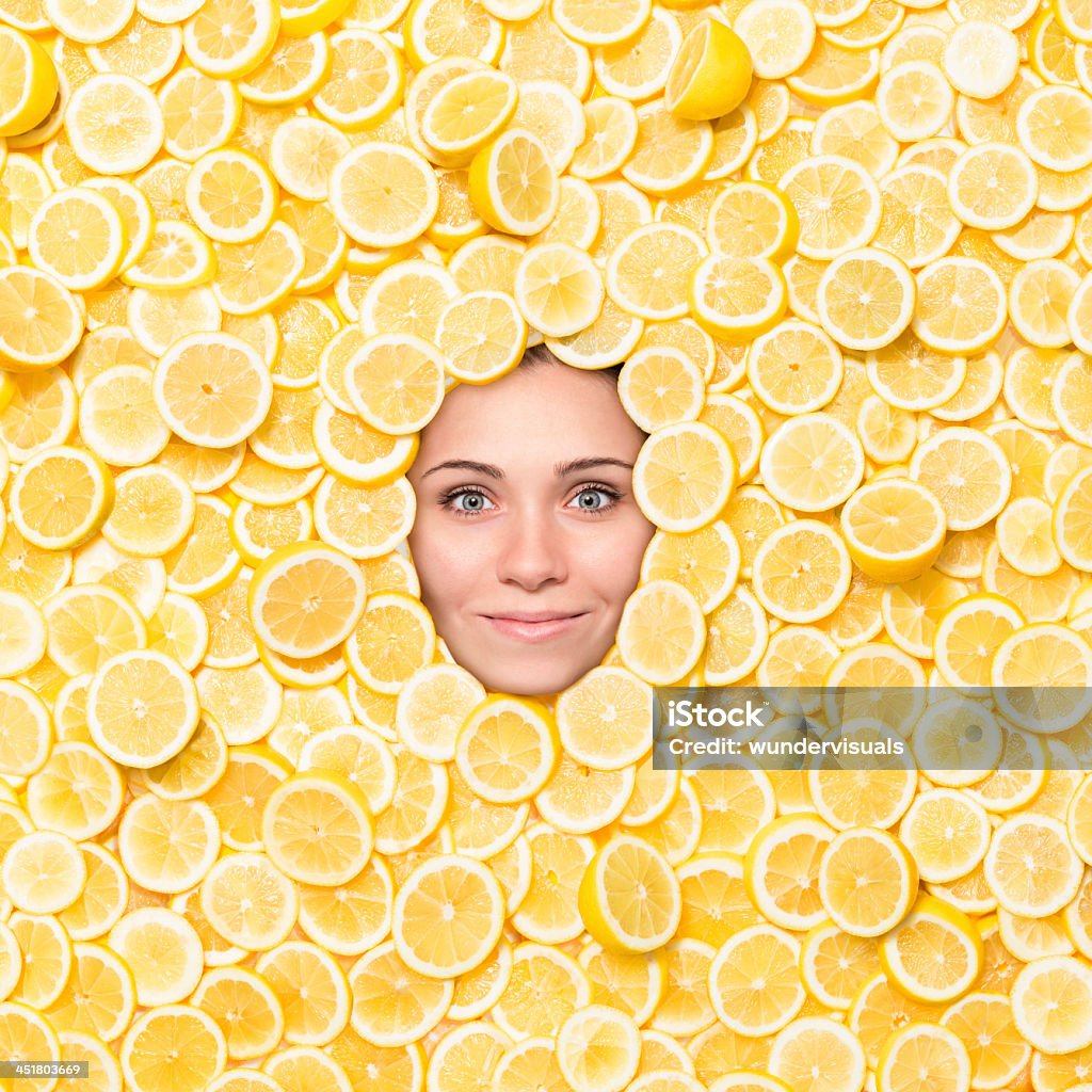 Mulher rosto Cercado com fatias de limão-siciliano - Foto de stock de Limão amarelo royalty-free