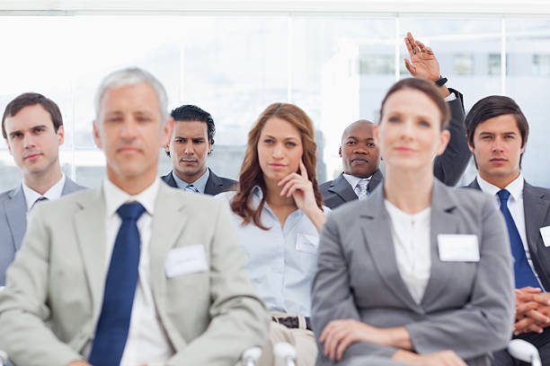 istock Businessman raising his hand for attention while sitting behind 451806453