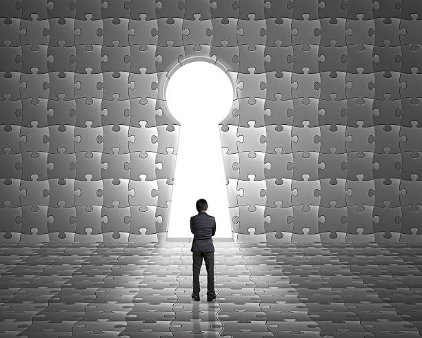 istock Businessman stand toward key hole shape door on puzzles wall 451819773