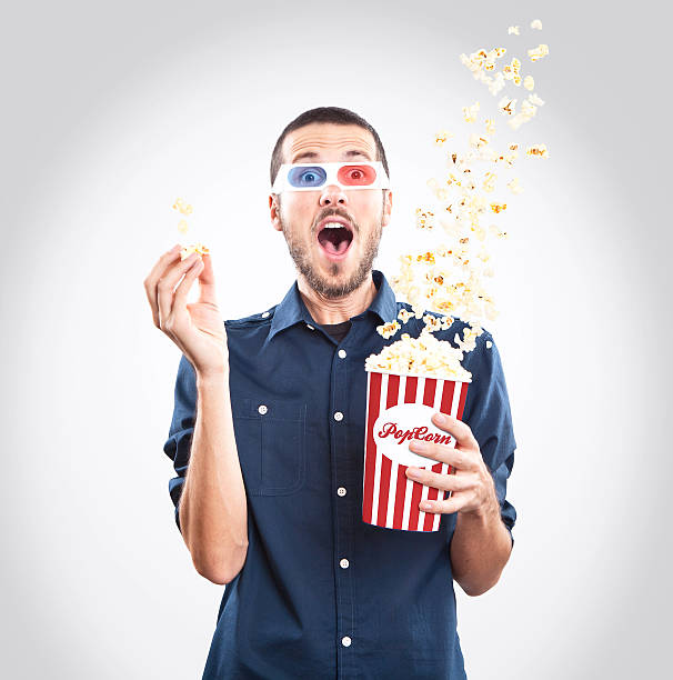 Joven viendo una película con 3d gafas y las palomitas de maíz - foto de stock