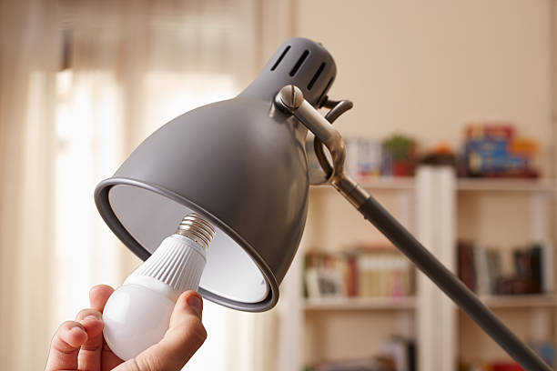mano cambiar una bombilla estándar para led - led lighting equipment light bulb installing fotografías e imágenes de stock