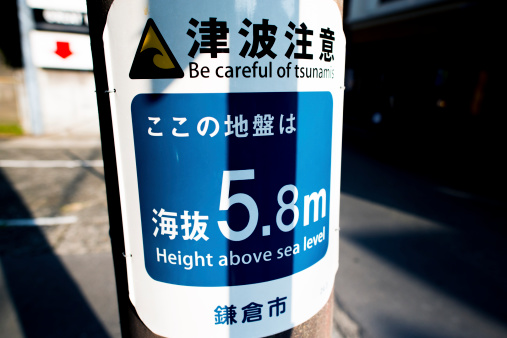 A sign warning of tsunamis in Japanese; at Kamakura, Japan