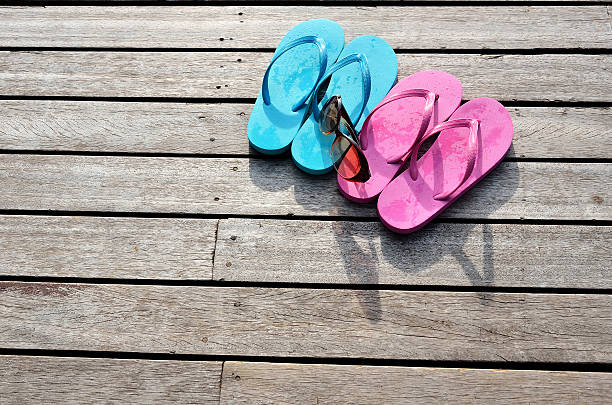 istock Colored flip flops and sunglasses on the wooden floor 451854731