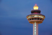 Changi Airport control tower against a dark cloudy sky