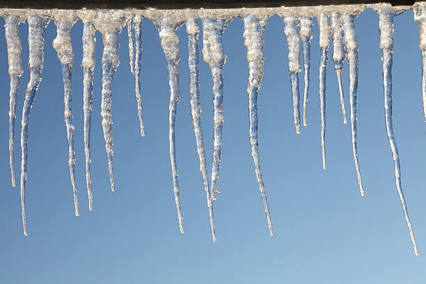 istock winter day with icicles in front of blue sky 451860255