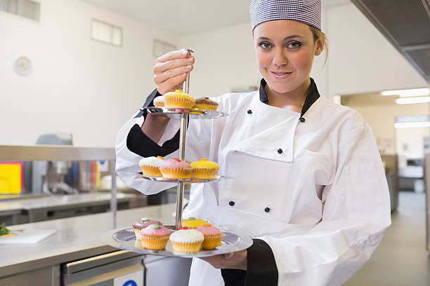 istock Happy chef holding a three tiered cake tray 451861013