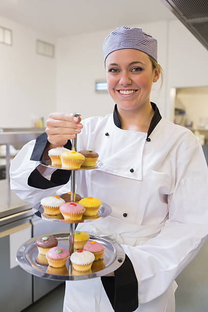 istock Happy chef holding three tier cake tray 451861101