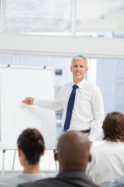 istock Mature businessman pointing towards a chart during presentation 451865505