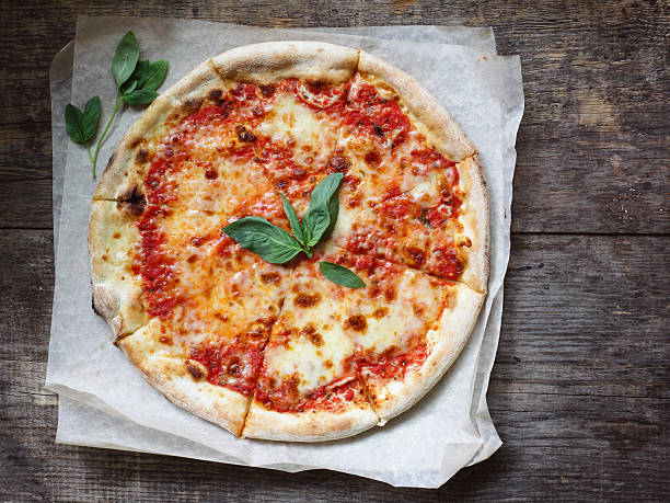 Margherita Pizza Domestic classic italian pizza margherita with tomatoes sauce, mozzarella and basil on a table. Margherita Pizza stock pictures, royalty-free photos & images