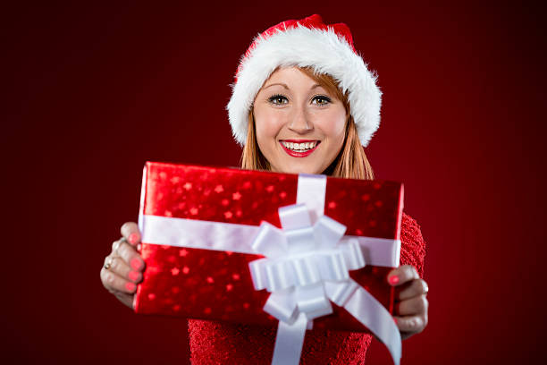 istock Woman with Santa hat holding present 451870497
