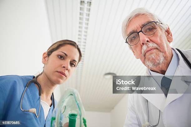 Nurse And A Doctor Putting An Oxygen Mask On Stock Photo - Download Image Now - 20-29 Years, 70-79 Years, Adult