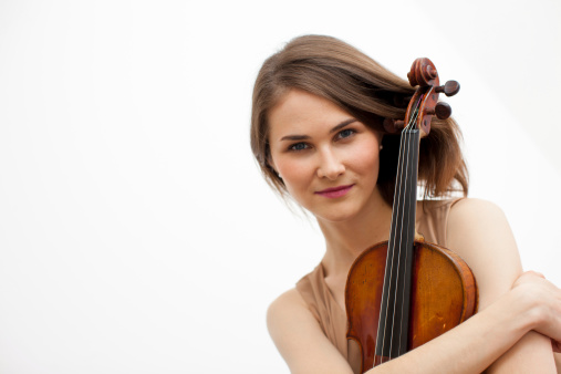 Young woman embracing a violin. White Background. Head and shoulders tilted studio shot.