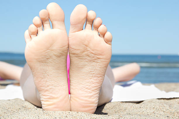 donna in piedi sulla spiaggia - human foot barefoot sole of foot human toe foto e immagini stock