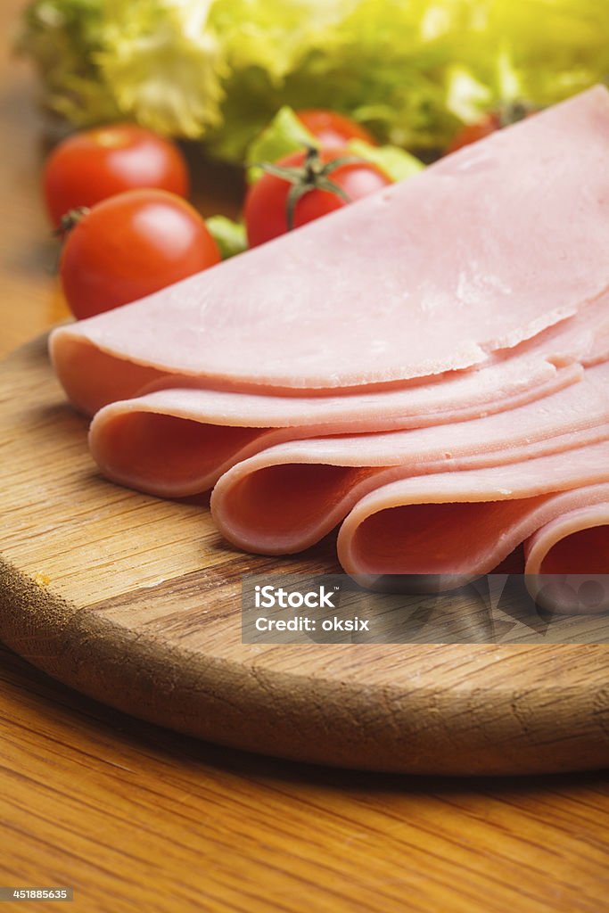 Ham slices Fresh ham slices with lattuce and cherry tomato on the wooden board Appetizer Stock Photo