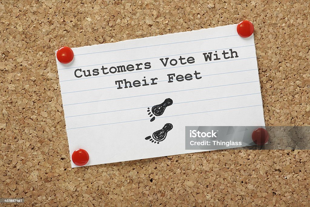 Customers Vote With Their Feet Customers Vote With Their Feet typed on a paper note pinned to a cork notice board. Business people know customers will move buying power elsewhere if service, value and delivery fail. Bulletin Board Stock Photo