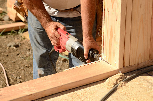 Reciprocating Building contractor worker using a reciprocating saw to cut out the door in the base plate of the wall for the first floor on a new home construciton project hand saw photos stock pictures, royalty-free photos & images