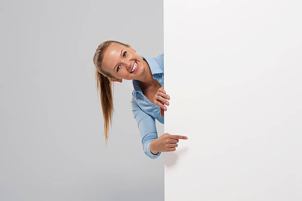 istock Smiling beautiful businesswoman pointing at whiteboard 451894961