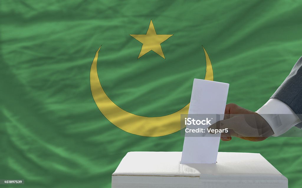 Homem de voto em eleições em frente a bandeira da Mauritânia - Royalty-free Adulto Foto de stock