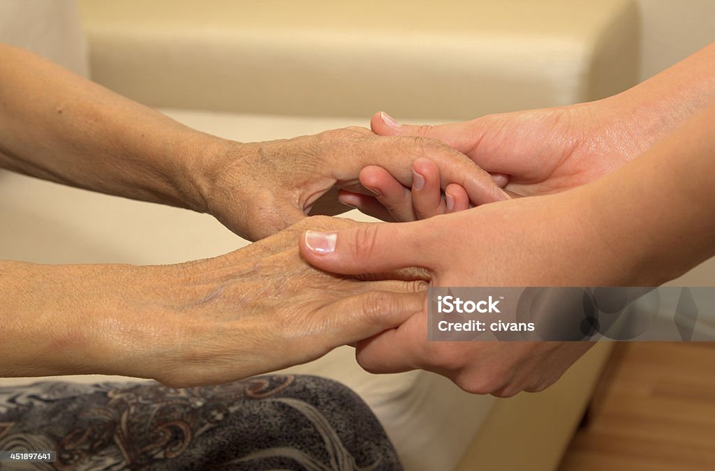 Old and Young Young woman is holding a senior woman's hands. 70-79 Years Stock Photo