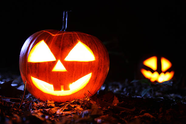 istock Halloween pumpkins in a forest at night 451919621