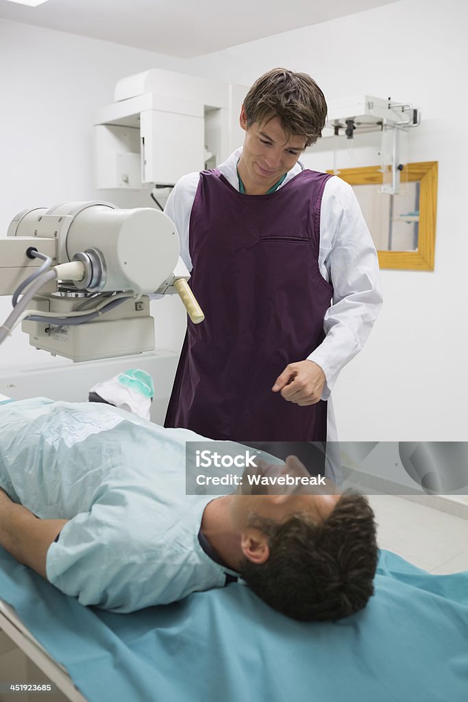 Smiling doctor doing a x-ray on his male patient - 로열티 프리 30-39세 스톡 사진