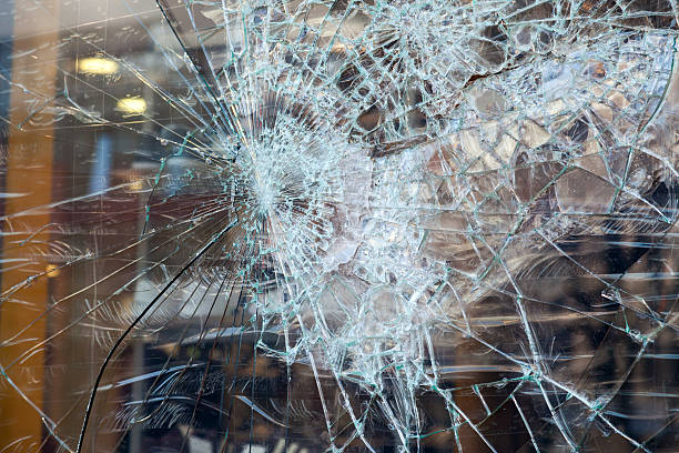 istock Closeup of smashed glass panel cracked and broken 451923863