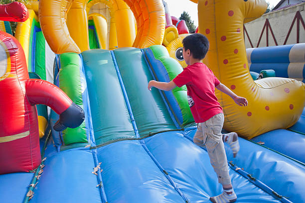 as crianças pequenas em um trampolim. - inflatable child jumping leisure games imagens e fotografias de stock