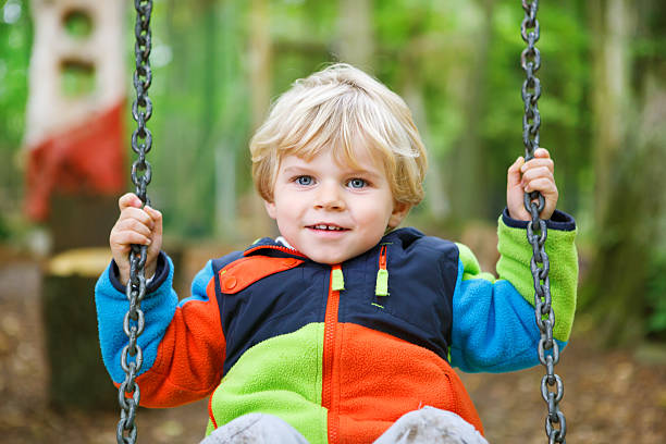 istock Beautiful toddler boy having fun on swing in autumn forest 451926151