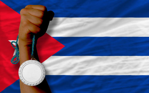 Holding silver medal for sport and national flag of cuba