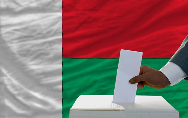 istock man voting on elections in front flag of madagascar 451929795