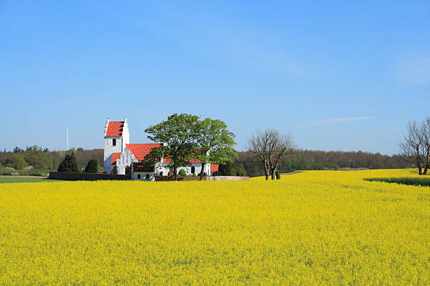 istock Idyllic country side parish church behind oilseed rape field 451963073
