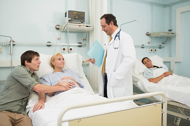 istock Obstetrician talking with his patient and her husband 451963957