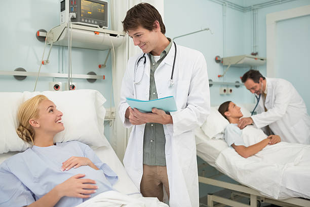 istock Obstetrician talking with a patient lying in bed 451964153