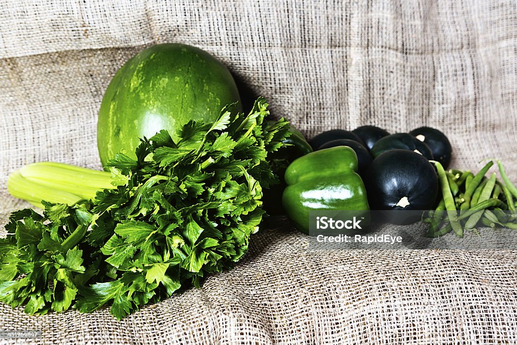 Green and good for you: selection of  fresh produce Green goodness: green beans, green peppers, watermelon, celery,  and gem squash on burlap at farmers market. Good, wholesome, vitamin-rich fare! Autumn Stock Photo